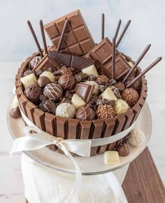 a cake with chocolates and marshmallows in it on a white plate