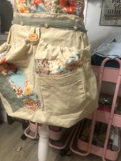 the apron is made from an old pair of jeans and has pockets for buttons on it