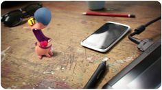 a small figurine sitting on top of a wooden table next to a cell phone