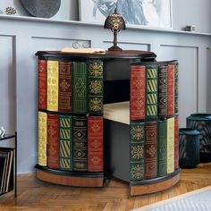 a book shelf with many books on it in front of a painting and other items