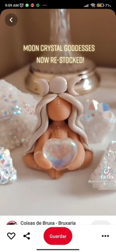 an image of a small doll sitting on top of a table next to some diamonds