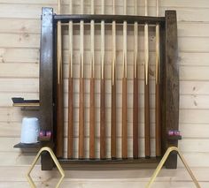 an old wooden rack with some knitting needles on it