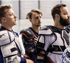 three men in protective gear standing next to each other