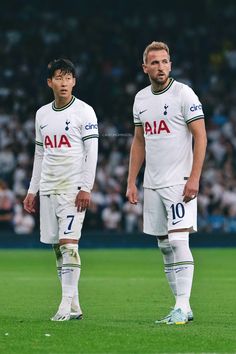 two soccer players standing next to each other on a field