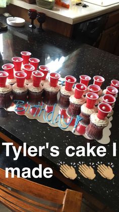 a table topped with lots of cupcakes covered in red frosting