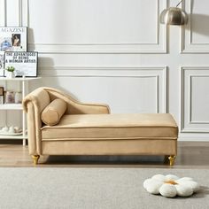 a chaise lounge chair sitting on top of a hard wood floor next to a white wall