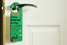 a door handle that is attached to a door with a sign on it saying caution little monsters at play