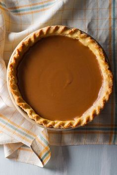 a chocolate pie sitting on top of a table next to a white cloth and napkin