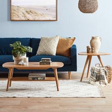 a living room filled with furniture and a painting on the wall above it's coffee table