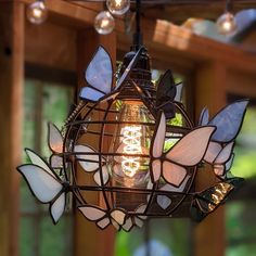 a light fixture with stained glass butterflies hanging from it's sides and lights on the ceiling