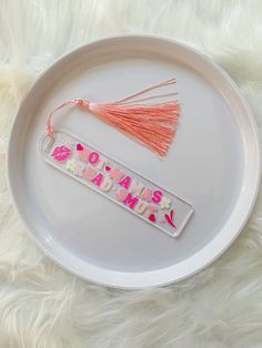 a white plate with pink tassels and the words i love my mama on it