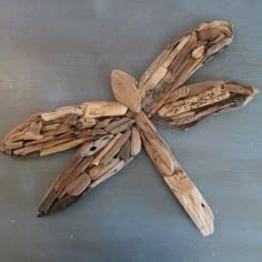 a dragonfly made out of driftwood sitting on top of a table