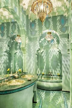 a bathroom with two sinks and a chandelier hanging from it's ceiling