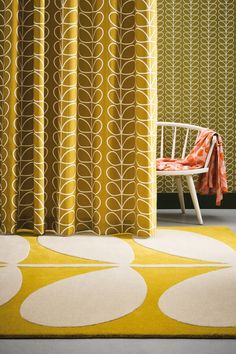 a chair sitting in front of a yellow and white curtain with circles pattern on it