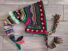 a crocheted hat and scarf laying on the floor