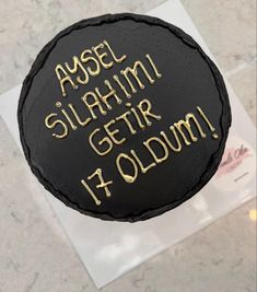 a black cake with gold writing on it