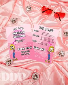 two pink flyers sitting on top of a pink satin covered bed next to crystal balls