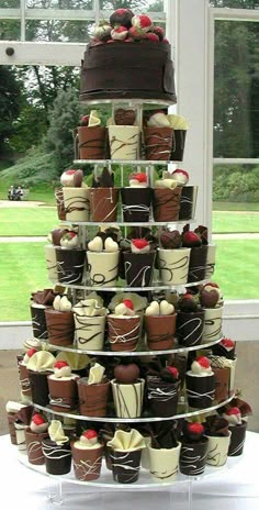 a very tall cake with many different types of cupcakes on it's sides