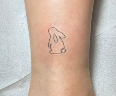 a small tattoo on the ankle of a person with a dog's head drawn on it