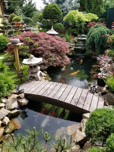 a wooden bridge over a small pond in a garden