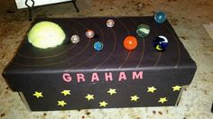 a box that is sitting on the ground with some balls and stars around it,