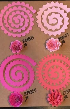 paper flowers are cut out and placed on a piece of brown paper with pink trim