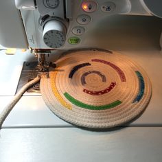 a close up of a sewing machine with a basket on the table next to it