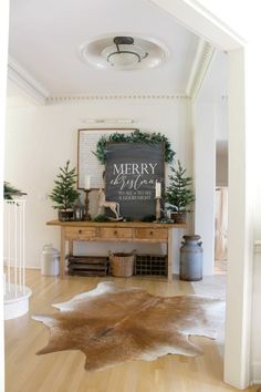 a merry christmas sign is on the wall above a table with plants and other decorations