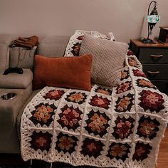 a couch with a crocheted blanket on top of it