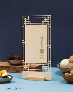 a wooden sign sitting on top of a table next to bowls of fruit and vegetables