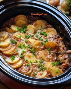 a crock pot filled with potatoes and meat