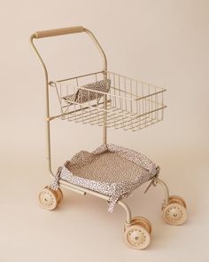 a toy shopping cart with two wheels and a basket on top