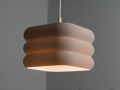 a light fixture hanging from the ceiling in a room with grey walls and flooring