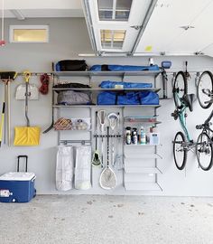 there is a bike hanging on the wall next to some shelves with bikes and other items