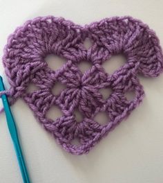 the crochet heart is next to a knitting needle