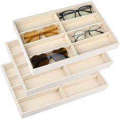 two pairs of glasses are sitting in a white box on top of another pair of glasses