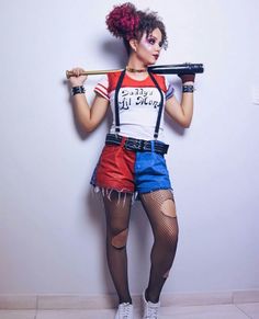 a woman with red hair and makeup holding a baseball bat in her hand while standing next to a wall