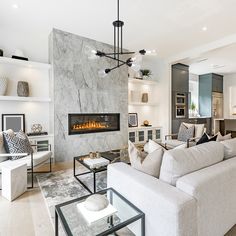 a living room filled with furniture and a fire place in the middle of it's wall