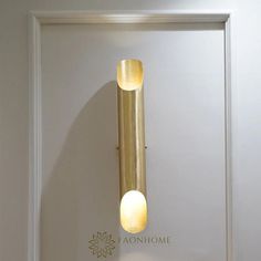 a wall mounted light on the side of a white door with a flower in it