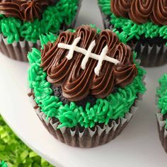 cupcakes decorated with chocolate frosting and green sprinkles on a plate