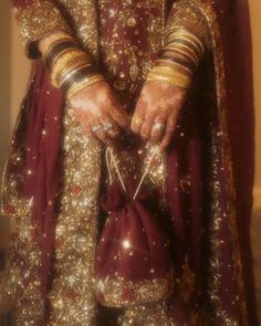 a man in a red and gold wedding outfit with his hands on the waistline