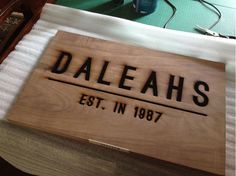 a wooden sign that reads daleahs est, in 1897 on top of a table