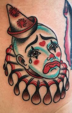 a close up of a tattoo on the side of a woman's stomach with an evil clown face