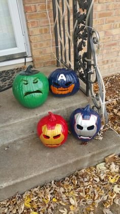 three pumpkins with faces painted on them are sitting on the front steps of a house