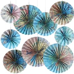 six paper fans hanging from strings on a white background, each with different colors and patterns