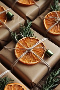 orange slices wrapped in brown paper and tied with twine, surrounded by evergreen sprigs