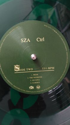 a green record with the words sza curl on it in gold and black lettering