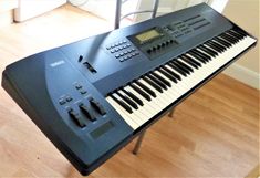 an electronic keyboard sitting on top of a wooden floor