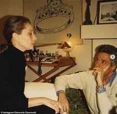 an older woman sitting next to a younger man on a couch in a living room