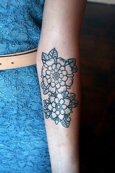 a woman's arm with a flower tattoo on it